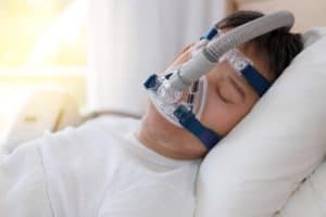 Sleeping with a CPAP mask on a pillow